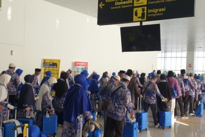 Jemaah umrah mengantre ke pintu masuk bandara menuju ruang tunggu penerbangan pesawat.