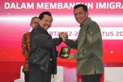 Dirjen Imigrasi Silmy Karim memberikan cenderamata kepada mantan Kepala Badan Intelijen Negara (BIN), A. M. Hendro Priyono usai menjadi pembicara FGD.