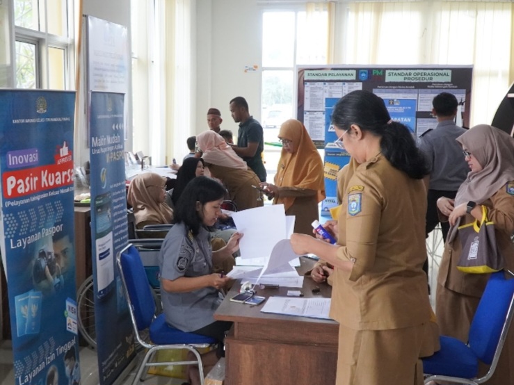 Petugas imigrasi sedang melayani pemohon yang memanfaatkan program Pasir Kuarsa di Kantor DPMPTK.