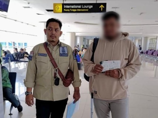LM, warga negara Kepulauan Solomon dikawal petugas di Bandara Internasional Juanda untuk dipulangkan ke negara asal.