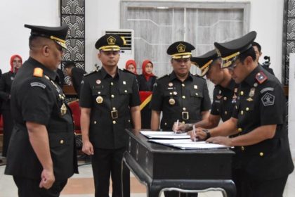 Kakanwil Kemenkumham Jatim R Andika Dwi Prasetya menyaksikan Kakanim Bandung yang baru, Agung Pramono (kanan), yang merupakan alumni Akademi Imigrasi (AIM) angkatan ke-7 menandatangani berita acara pelantikan.