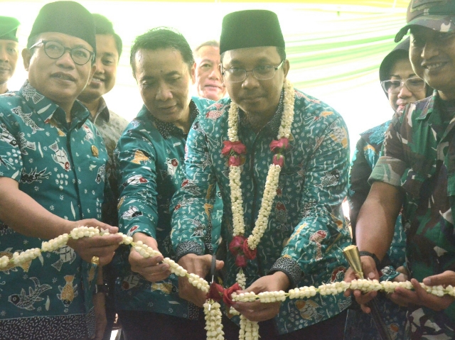 Bupati Sidoarjo Gus Muhdlor Ali memotong pita menandai peresmian puskesmas bersama jajaran samping.