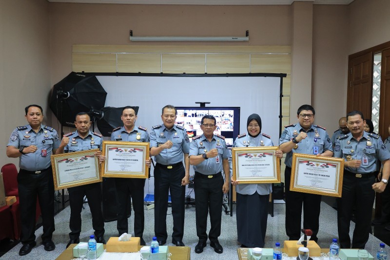 Kakanwil Kemenkumham Jatim Heni Yuwono bersama Ka-UPT yang meraih penghargaan layanan berbasis HAM foto bersama sambil menunjukkan piagam.