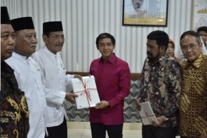 Wakil Menteri ATR/Waka BPN, Raja Juli Antoni, memberikan sertifikat tanah wakaf kepada masyarakat disaksikan Kepala Kantor Pertanahan Surabaya II, Stanley.