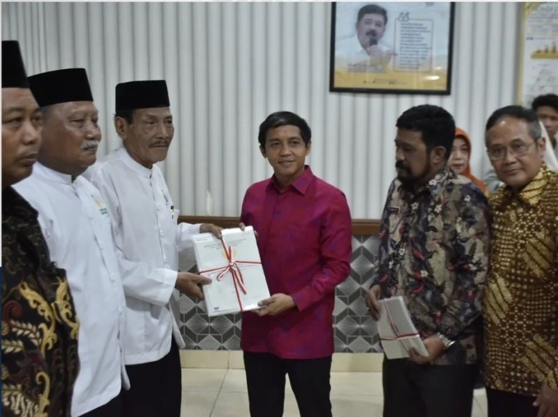 Wakil Menteri ATR/Waka BPN, Raja Juli Antoni, memberikan sertifikat tanah wakaf kepada masyarakat disaksikan Kepala Kantor Pertanahan Surabaya II, Stanley.
