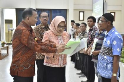 Kakantah Tuban Yan mendampingi anggota Komisi II DPR RI Haeny Relawati Rini Widyastuti, menyerahkan sertifikat tanah PTSL secara simbolis kepada delapan orang.