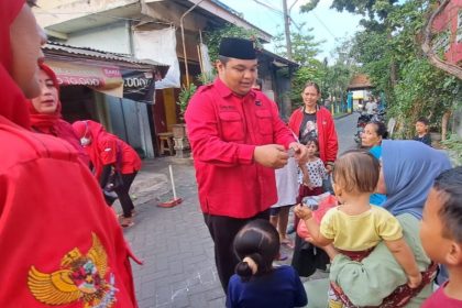 Wakil Sekretaris Dewan Pimpinan Cabang PDI Perjuangan Kota Surabaya Achmad Hidayat membagikan telur kepada warga secara gratis.