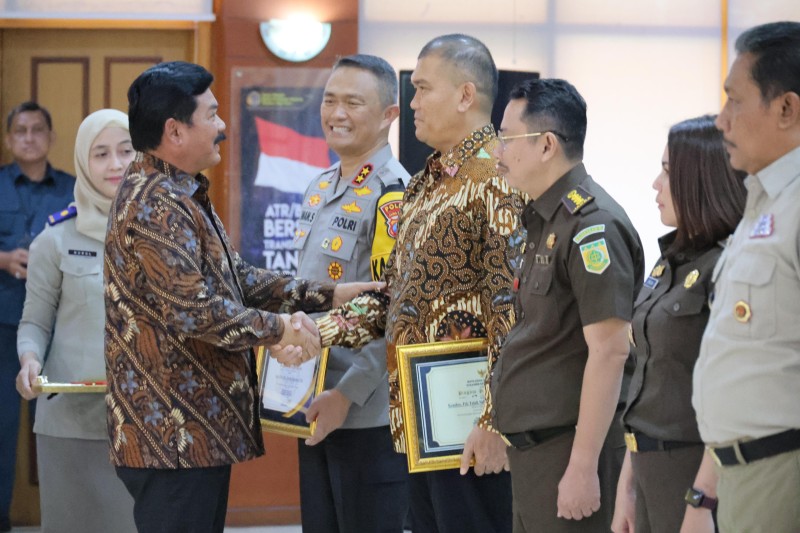 Menteri ATR/Kepala BPN Hadi Tjahjanto memberikan ucapan selamat kepada Direskrimum Kombespol Totok Suhariyanto usai memasangkan Pin Emas di Kanwil BPN Jatim.