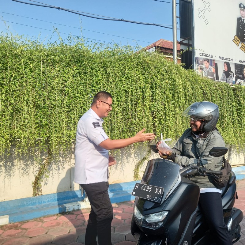 Kepala Kantor Imigrasi Semarang, Guntur Sahat Hamonangan membagikan takjil gratis kepada pengendara yang melintas di depan kanim. 