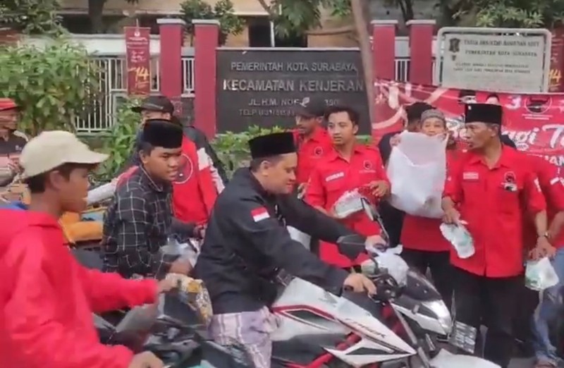 Kader dan simpatisan PDI Perjuangan PAC Kenjeran membagikan takjil di depan Kecamatan Kenjeran, Jalan Kedungcowek.