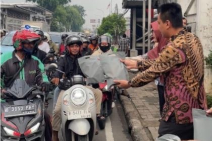 Kepala Kantor Imigrasi Jakarta Timur, Rendra Mauliansyah membagikan takjil kepada pengendara yang melintas di depan kantor.