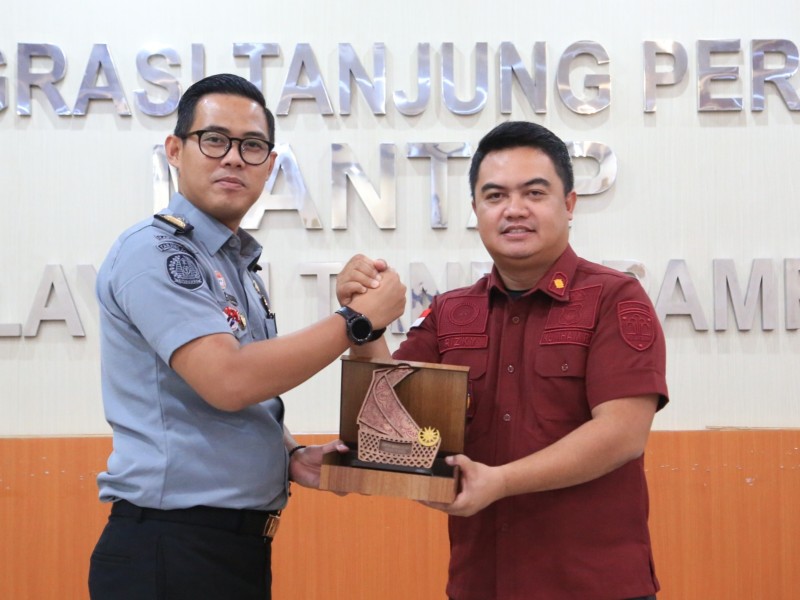 Kasubag TU Kantor Imigrasi Tanjung Perak Dandi Permana (kiri) menerima cenderamata dari Kabid Tikkim Imigrasi Batam, Rizky Yudha Ikawira.