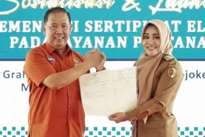 Kepala Kantor Pertanahan Kabupaten Mojokerto, Budiono, A.Ptnh., M.H menerima cenderamata Bupati Mojokerto, dr. Ikfina Fahmawati, M.Si dalam acara launching kemarin.