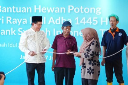 Direktur Utama BSI Hery Gunardi (kiri) menyerahkan secara simbolik hewan potong kepada duafa di Jakarta.