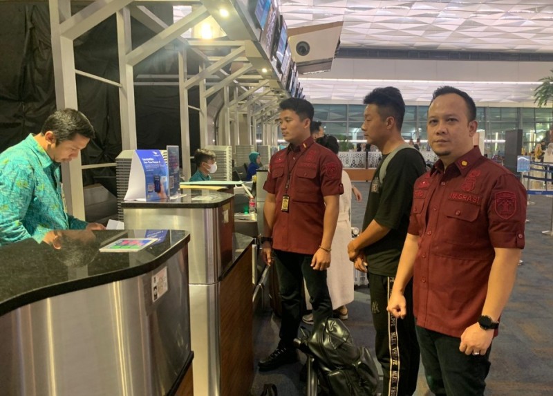 Petugas Imigrasi Tanjung Perak mengawal WNA asal China untuk dideportasi melalui Bandara Internasional Juanda, Sidoarjo.