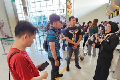 Wu Chi Lung (kiri) bersama petugas dari Imigrasi Surabaya dan pihak maskapai menunggu keberangkatan di Bandara Internasional Juanda.