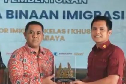 Kepala Seksi Intelijen, Imigrasi Surabaya, Gerry Baringin (kanan) memberikan kenang-kenangan kepada tokoh masyarakat setempat.