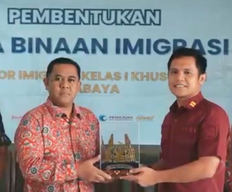 Kepala Seksi Intelijen, Imigrasi Surabaya, Gerry Baringin (kanan) memberikan kenang-kenangan kepada tokoh masyarakat setempat.