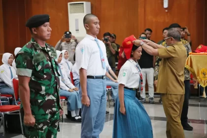 Wawali Armuji menandai pembukaan Diklat Paskibra di Graha Sawunggaling dengan mengenakan topi ke salah satu perwakilan peserta.