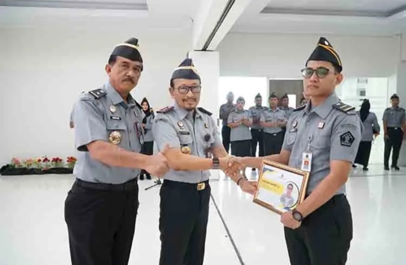 Kakanwil Kemenkumham Maluku Hendro Tri Prasetyo (tengah) memberikan penghargaan kepada Suhendra Rahmat di sela-sela apel pagi, kemarin.