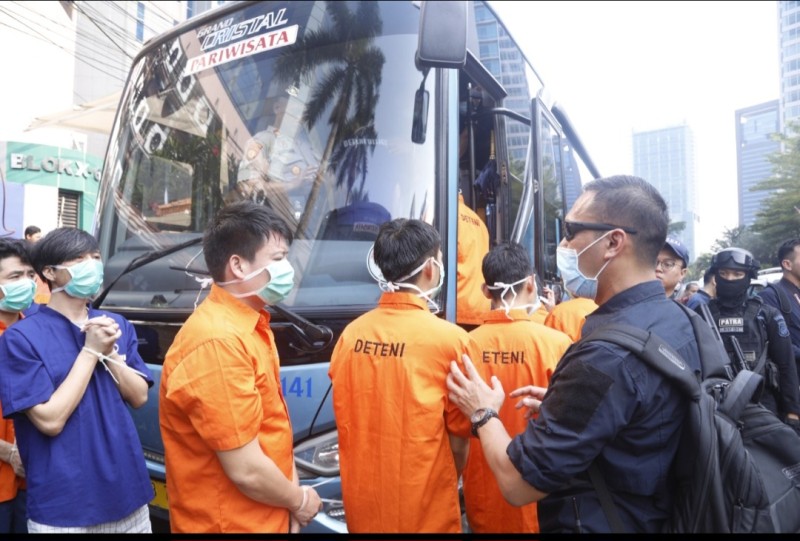 Petugas imigrasi mengawal WNA untuk dideportasi sekeluarga dari ruang deteni.