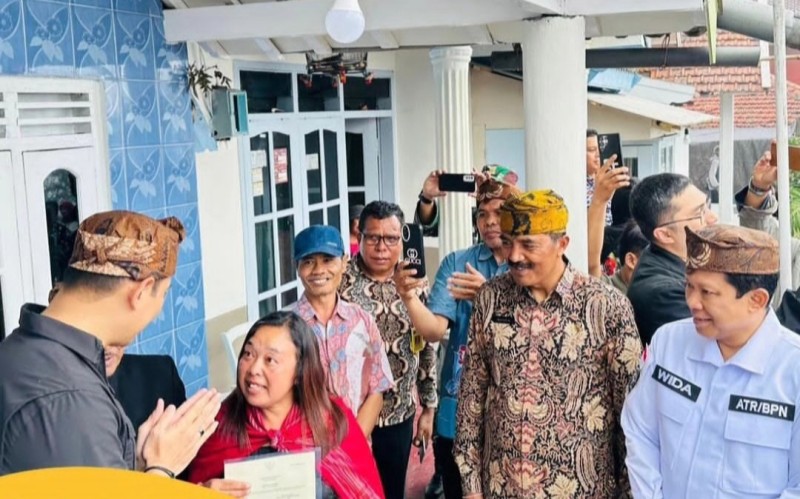 Kepala Kantor Pertanahan Kabupaten Probolinggo, Wida Rihardyan Adjie mendampingi Menteri AHY menyerahkan sertifikat bagi masyarakat Kawasan Taman Nasional Bromo.