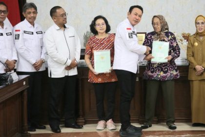 Kakanwil BPN Jatim Lampri menyerahkan sertifikat HGB di atas HPL kepada warga penghuni surat ijo disaksikan Pjs Walikota Surabaya Restu Novi Widiani.