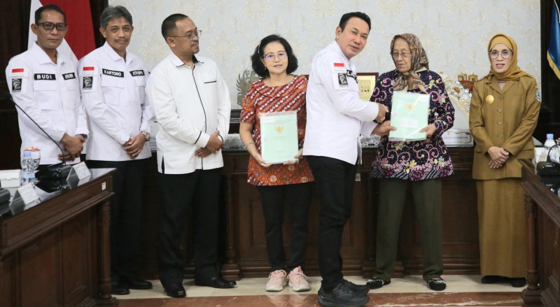 Kakanwil BPN Jatim Lampri menyerahkan sertifikat HGB di atas HPL kepada warga penghuni surat ijo disaksikan Pjs Walikota Surabaya Restu Novi Widiani.