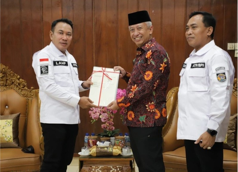 Kakanwil BPN Jatim Lampri (kiri) menyerahkan 36 sertipikat hak pakai kepada Pj Bupati Nganjuk Sri Handoko disaksikan Kakantah Nganjuk, Suwono (kanan).