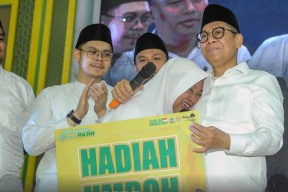 Anggota DPRD Sidoarjo, Adiel Muhammad Kanantha (kiri) mendampingi Adies Kadir menyerahkan hadiah umroh kepada relawan AKAR yang beruntung.