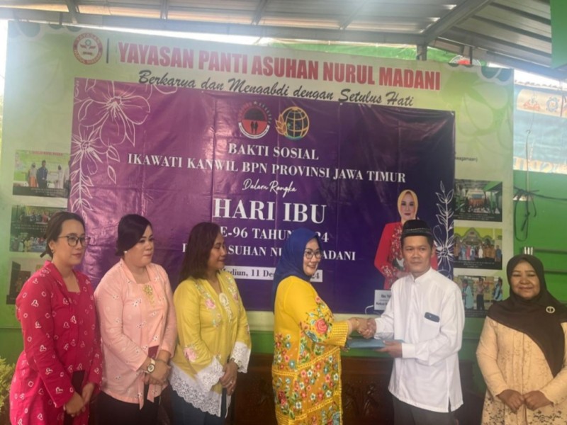 Ketua Ikawati Badan Pertanahan Nasional (BPN) Jatim Yetty Yetty Nurbuati Krystianti Lampri memberikan tali asih kepada pengurus panti disaksikan pengurus lainnya.