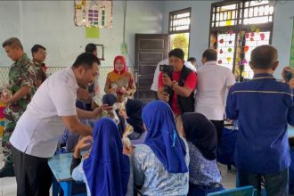 Kepala Kantor Imigrasi Sumbawa Barat, Putu Agus Eka Putra berbaur dengan anak-anak membagikan sarapan gratis.