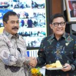 Menteri Imigrasi dan Pemasyarakatan, Agus Andrianto memberikan potongan tumpeng kepada Plt Direktur Jenderal Imigrasi Saffar Muhammad Godam.