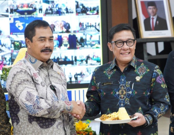 Menteri Imigrasi dan Pemasyarakatan, Agus Andrianto memberikan potongan tumpeng kepada Plt Direktur Jenderal Imigrasi Saffar Muhammad Godam.