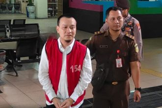 Ivan Sugiamto, terdakwa kasus perundingan digiring petugas menuju ruang sidang Pengadilan Negeri (PN) Surabaya, Jalan Arjuna.