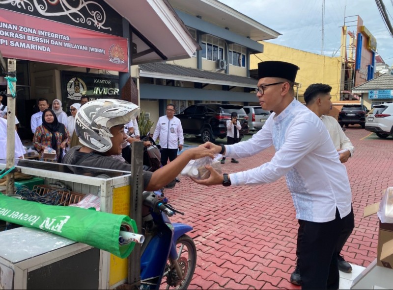 Kepala Kantor Imigrasi Samarinda, Yudhistira Yudha Permana, memberikan bingkisan kepada warga yang melintas di depan kantor imigrasi menjelang berbuka puasa.