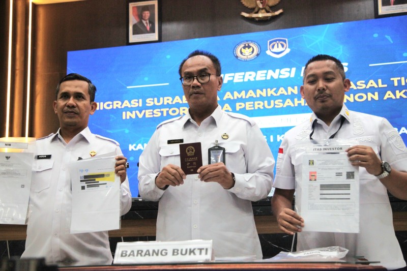 Kakanim Surabaya Agus Winarto, Kakanwil Ditjen Imigrasi Jatim Novianto Sulastono, dan Kabid Inteldakim Dodi Cipto Gunawan, menunjukkan BB milik WNA Tiongkok.