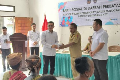 Kakanim Atambua, Putu Agus Eka Putra (kanan) menyaksikan penyerahan bantuan oleh Kakanwil Ditjen Imigrasi NTT, Arvin Gumilang kepada masyarakat Raihat.
