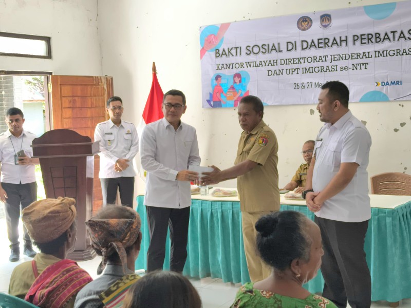 Kakanim Atambua, Putu Agus Eka Putra (kanan) menyaksikan penyerahan bantuan oleh Kakanwil Ditjen Imigrasi NTT, Arvin Gumilang kepada masyarakat Raihat.