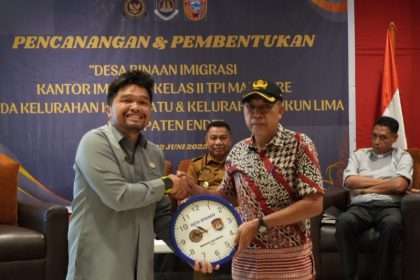 Kepala Kantor Imigrasi Kelas II TPI Maumere, Mangatur Hadi Putra Simanjuntak, memberikan cenderamata kepada Lurah setempat.