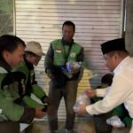 Tokoh muda PDIP Surabaya, Achmad Hidayat, membagikan nasi kuning di kawasan Jalan Tunjungan.