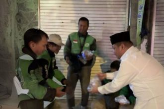 Tokoh muda PDIP Surabaya, Achmad Hidayat, membagikan nasi kuning di kawasan Jalan Tunjungan.