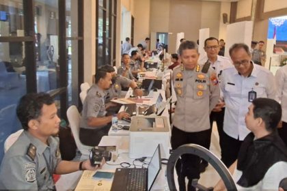 Kakanwil Ditjen Imigrasi Jatim, Novianto Sulastono bersama Kepala Biro SDM Polda Jatim, Kombespol Ari Wibowo, berbincang dengan pemohon paspor di Mapolda Jatim.