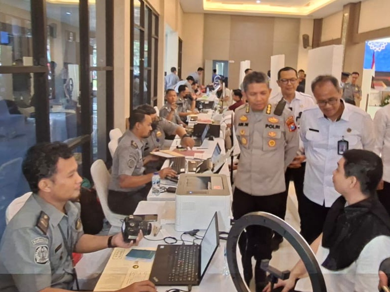 Kakanwil Ditjen Imigrasi Jatim, Novianto Sulastono bersama Kepala Biro SDM Polda Jatim, Kombespol Ari Wibowo, berbincang dengan pemohon paspor di Mapolda Jatim.