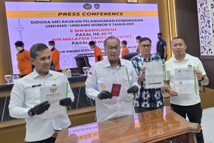 Kakanwil Ditjen Imigrasi Jawa Timur, Novianto Sulastono bersama Kakanim Surabaya Agus Winarto dan Kabid Wasdakim Dodi Cipto Gunawan menunjukkan BB milik orang asing yang diamankan.
