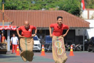 Lomba balap karung yang digelar di pelataran Kantor Kemenkum Jatim, di Jalan Kayun, Surabaya mewarnai peringatan HUT RI ke-80 di tahun ini.