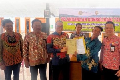 Kepala Kantor Pertanahan Kabupaten Mojokerto, Mateus Joko Slameto, menyerahkan sertifikat konsolidasi tanah..