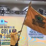 Adam Rusydi, S.Pd., M.Pd., mengibarkan bendera Golkar setelah terpilih kembali untuk kedua kalinya memimpin Partai Golkar di Kabupaten Sidoarjo.