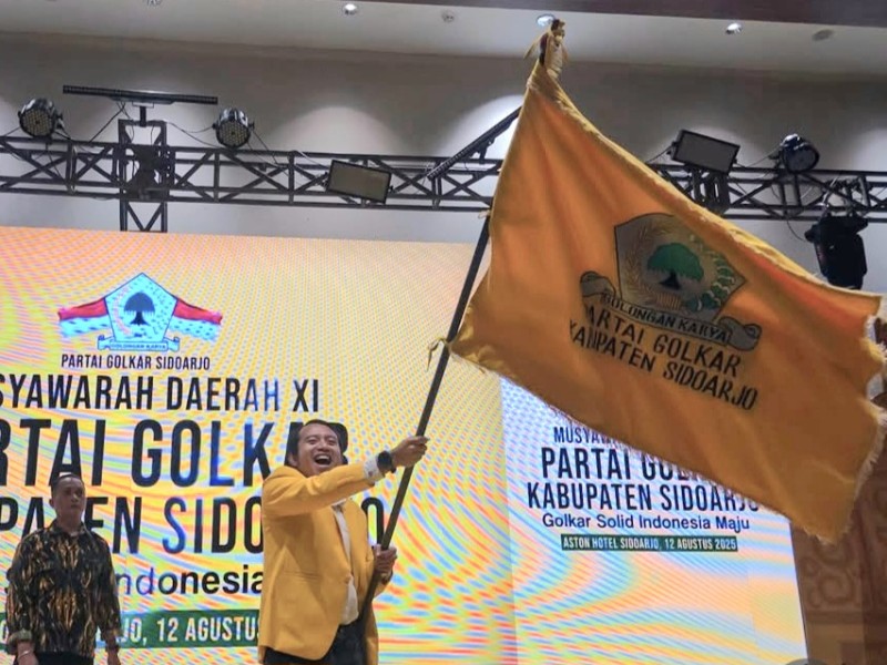 Adam Rusydi, S.Pd., M.Pd., mengibarkan bendera Golkar setelah terpilih kembali untuk kedua kalinya memimpin Partai Golkar di Kabupaten Sidoarjo.