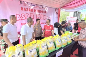 Sekjen Imigrasi dan Pemasyarakatan, Asep Kurnia berbincang dengan Kapolresta Sidoarjo, Kombespol Christian Tobing dalam kegiatan Pasar Murah di Kantor Imigrasi Surabaya.